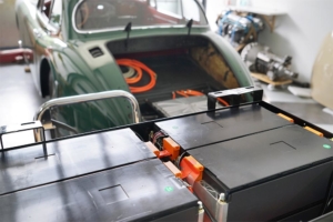 Im Vordergrund die hintere Batteriebox mit Batteriemodulen befüllt. Im Hintergrund das Heck des Jaguars XK150.