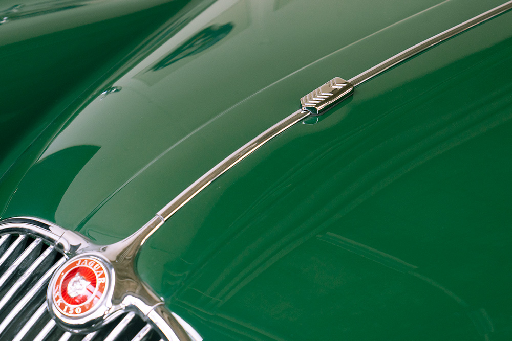 Haube des Jaguar XK150 ohne die sonst übliche Kühlerfigur in Form eines hüpfenden Jaguars. Diese wurde ersetzt durch eine Abdeckung mit stilisiertem Firmenlogo der Manufaktur Marton. Ein stilisiertes doppeltes M.