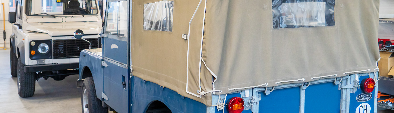 Land Rover Serie I und Land Rover Defender wurden auf Elektroantrieb umgebaut und stehen sich gegenüber.