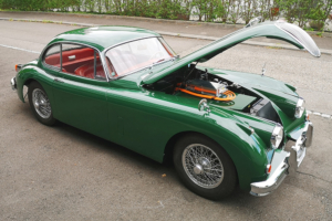 Jaguar XK 150, halbseitliche Ansicht, das Fahrzeug steht mit offener Haube da.