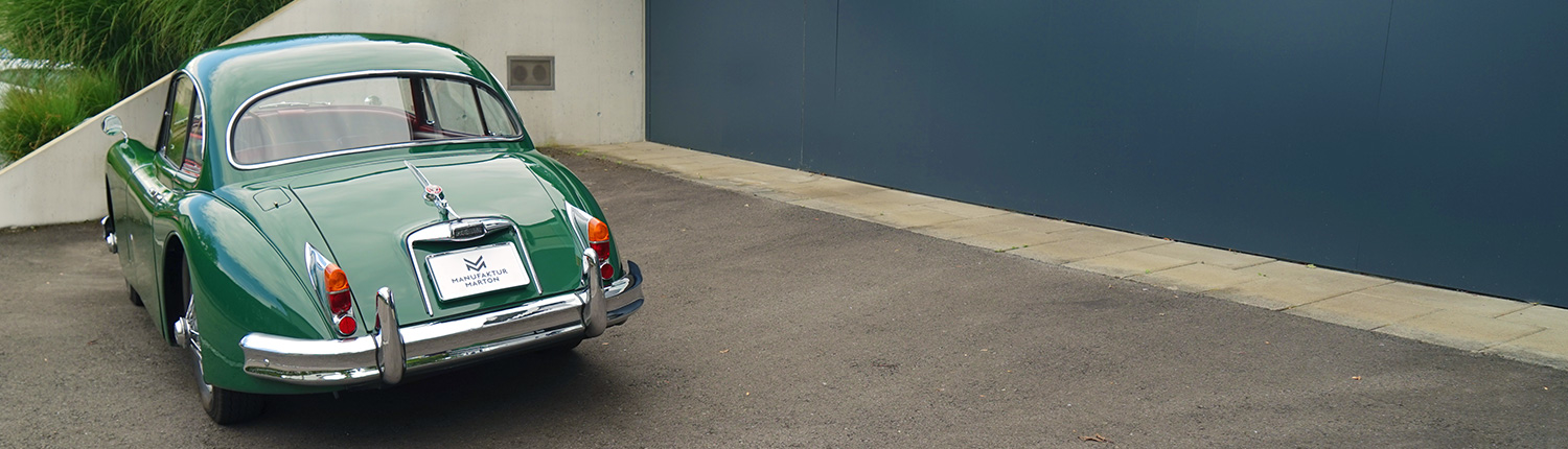 Elektrifizierter Jaguar XK 150 steht auf dem Parkplatz zur Probefahrt bereit.