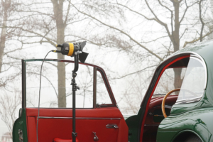 Jaguar XK 150 mit offener Türe. Eine Lampe leuchtet das Interieur für Kameraaufnahmen aus