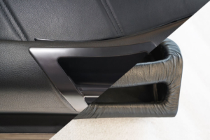 DeLorean neue Türhaltegriffe - Vergleich neu und alt. Der alte Haltegriff war ein Kunststoffteil mit faltiger Lederoptik, der neue Griff kommt glatt und schnörkellos daher.