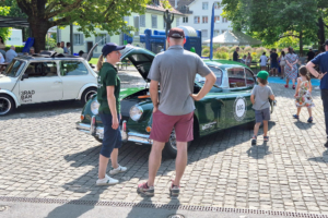 Zwei Personen besprechen den elektrifizierten Jaguar XK150 an der Wheel Jam in Baar 2024