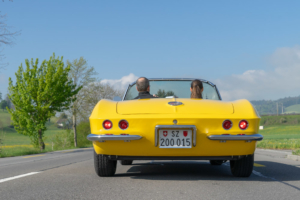 Ansicht fahrende Corvette von hinten mit zwei Insassen