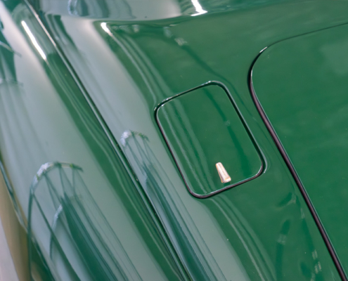 DSC02183_manufakturmarton_ladedose_blog Hinter dem ehemaligen Tankdeckel befindet sich die Ladedose des elektrifizierten Jaguar XK150. Statt eines Schlosses ist nun ein chromefarbiger kleiner Halter angebracht, an dem die Klappe angehoben werden kann