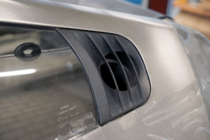 Detailansicht eines DeLorean, hinteres Seitenfenster, und am Ende des Fensters ein Einlass für die Motorenkühlung.