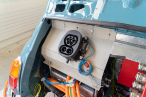 Planung Positionierung der Ladedose im Fiat 500. Man blickt auf das offene Heck des Autos, die Ladedose ist vorerst an einer Halterung aus gefaltetem Karton montiert.