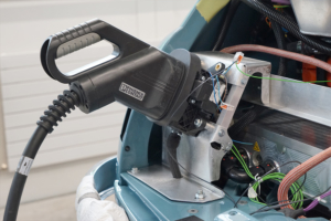 Bei offener Heckklappe ist der CCS-Stecker eingesteckt. Eine Konstruktion aus Aluminium hält die Ladedose.