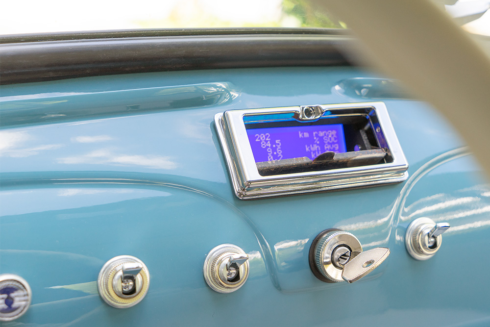 The display can be concealed behind the original ashtray flap A view of the dashboard of a Fiat 500, painted in the same colour as the car (medium blue). Where the ashtray used to be, there is a small display showing information such as fuel consumption and remaining range.