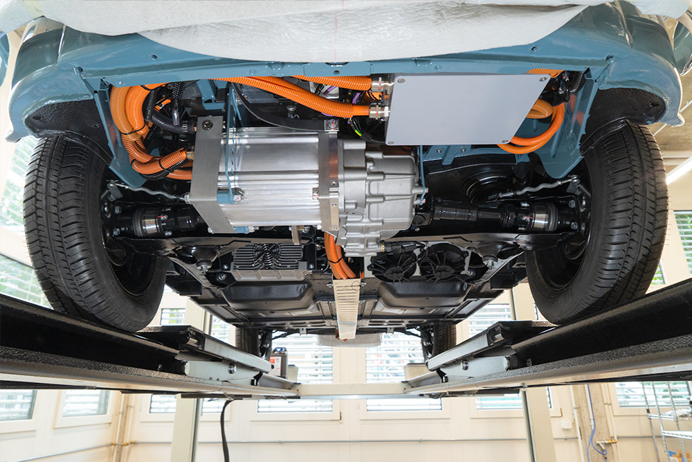 View from below showing the motor A view of the underside of a vehicle. You can see cables and an electric motor with a gearbox/differential.