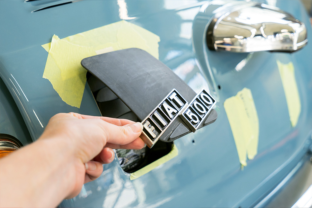 At the rear of the vehicle is a new charging flap, which is still in development An opening at the rear of the blue Fiat 500, which can be closed with a plastic flap. In the picture, it is half-open and bears the “Fiat 500” logo.