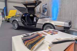 Ein Tisch mit Stoffmustern, im Hintergrund der DeLorean