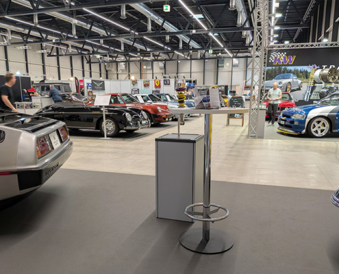 manufakturmarton_SCW2026_20260531_065808680 sicht vom Messestand aus in die Messehalle. Viele Fahrzeuge, vor allem Porsche