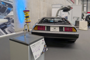 Fahrwerk mit DeLorean im Hintergrund. Die Feder des Fahrwerks ist gelb.